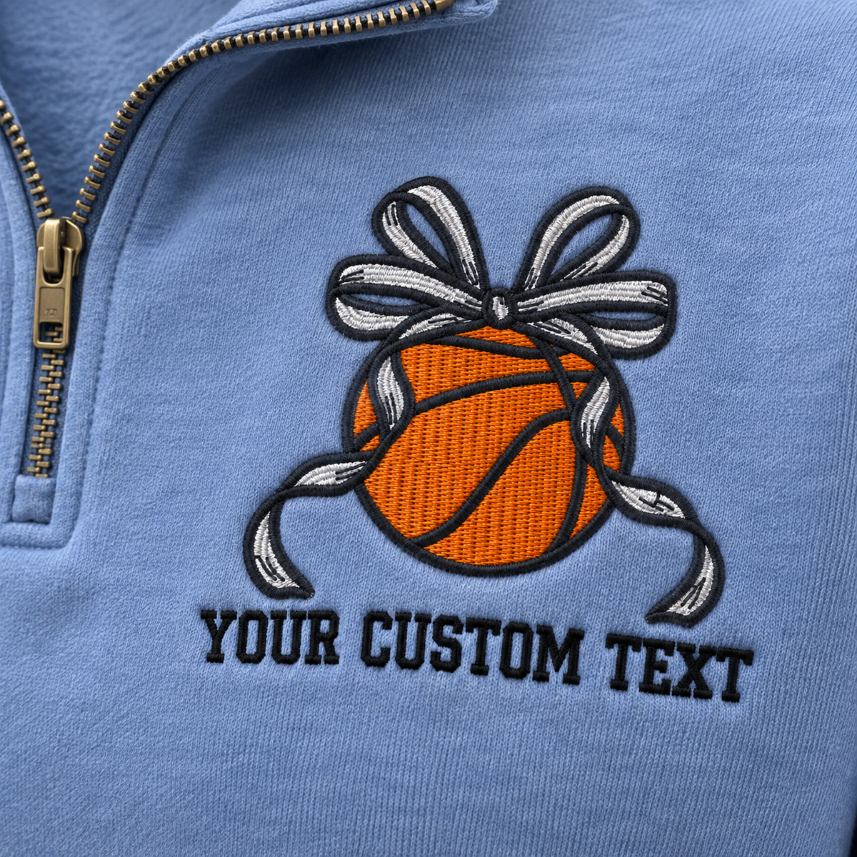 Close-up of basketball bow and custom text embroidered on a Blue Jean quarter zip