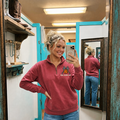 Woman wearing a Crimson Comfort Colors quarter zip with custom basketball bow left chest embroidery