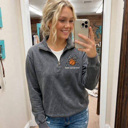 Woman wearing a Pepper Comfort Colors quarter zip with custom basketball bow embroidery