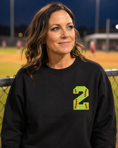 Black personalized softball number 2 appliqué Gildan Heavy Blend sweatshirt at a night game