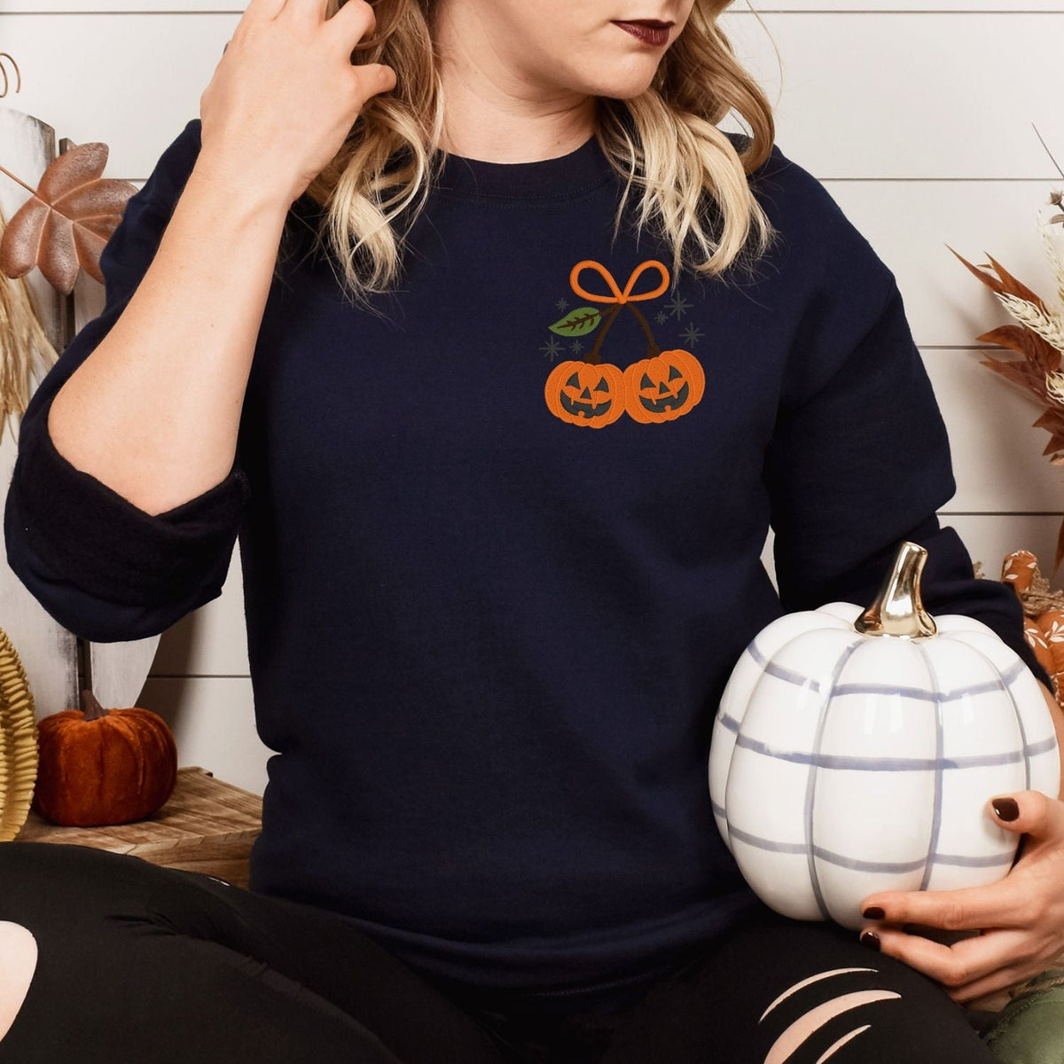 Navy embroidered pumpkin bow sweatshirt styled with a white pumpkin
