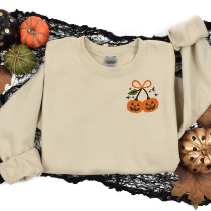 Sand pumpkin bow embroidered crewneck in a Halloween flat lay