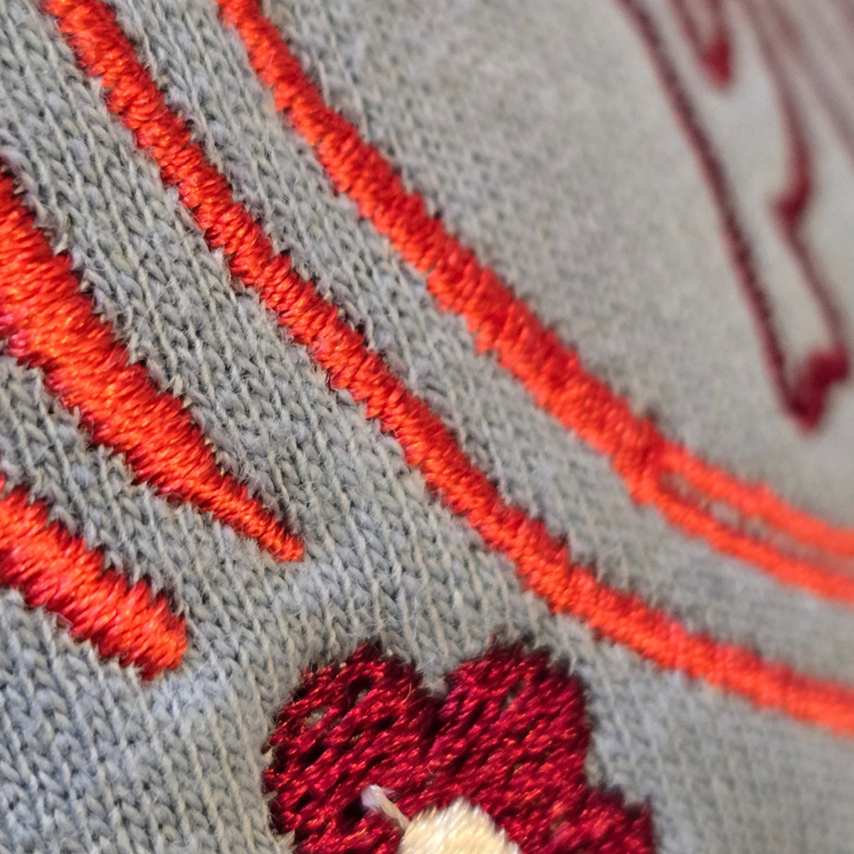 Close-up of dense orange and burgundy embroidery stitching on the Pumpkin Patch sweatshirt