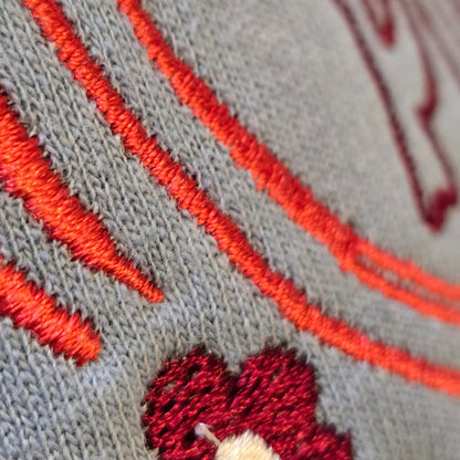 Close-up of dense orange and burgundy embroidery stitching on the Pumpkin Patch sweatshirt