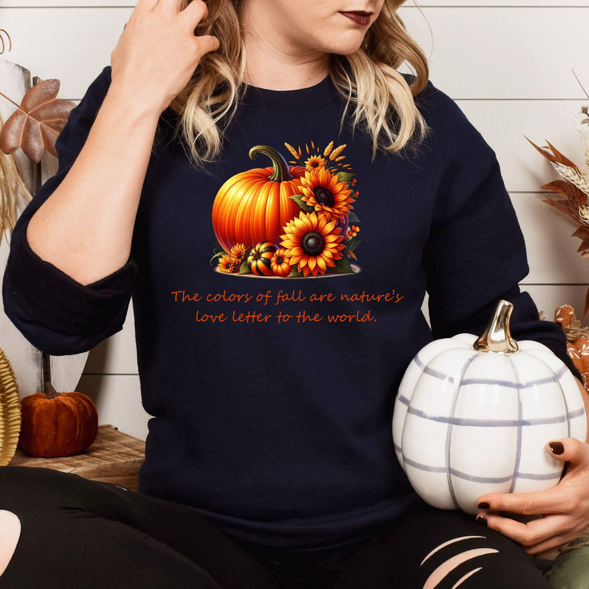 Navy pumpkin sunflower graphic sweatshirt modeled with a white pumpkin