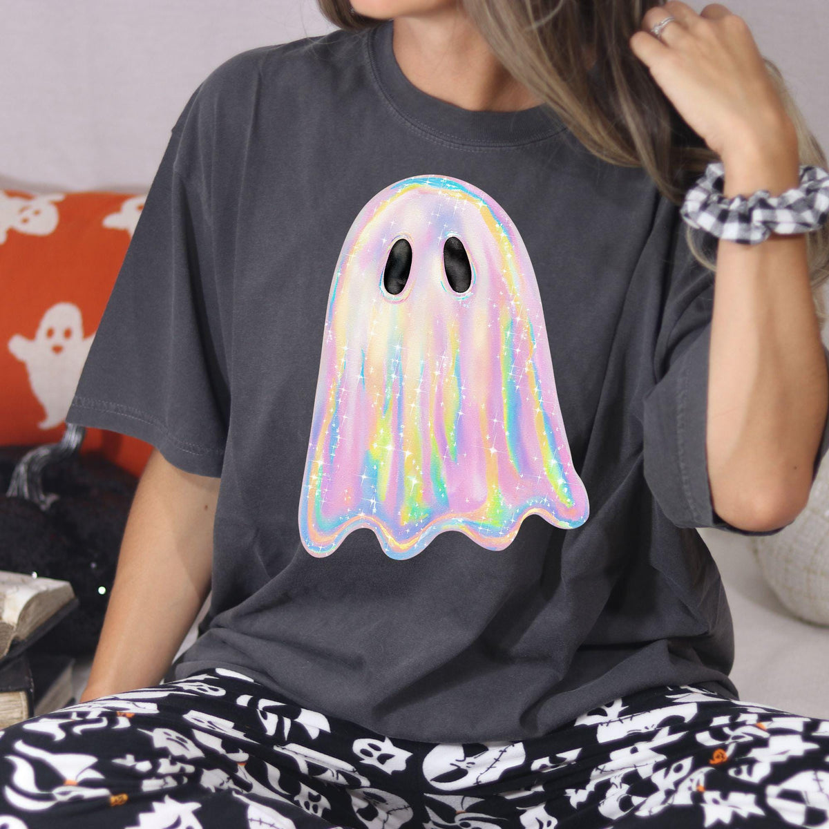 Woman seated in charcoal oversized T-shirt with rainbow pastel ghost graphic