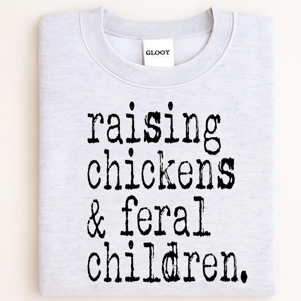 Folded ash gray Raising Chickens and Feral Children crewneck