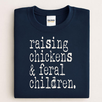 Folded navy sweatshirt reading Raising Chickens and Feral Children