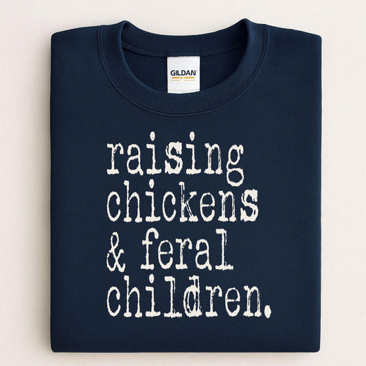 Folded navy sweatshirt reading Raising Chickens and Feral Children