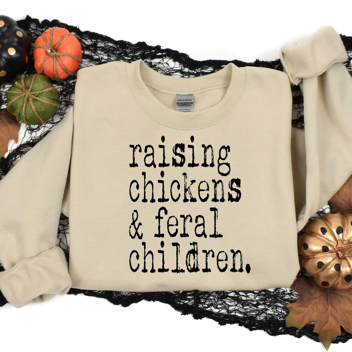 Sand Raising Chickens and Feral Children sweatshirt in a Halloween flat lay