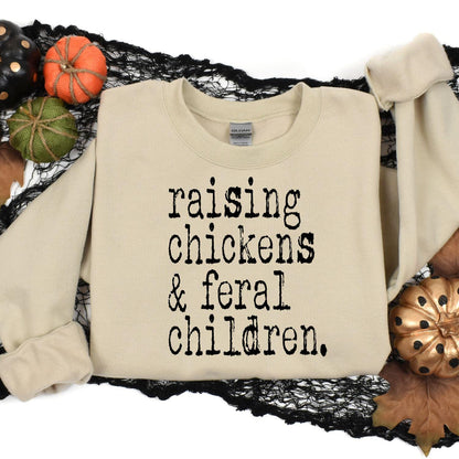 Sand Raising Chickens and Feral Children sweatshirt in a Halloween flat lay