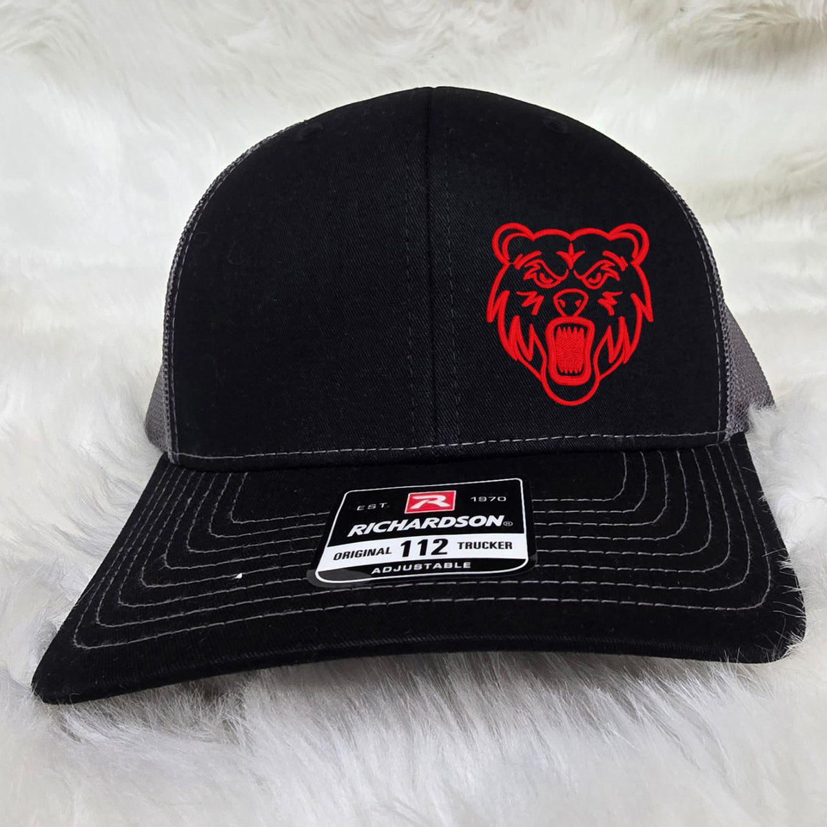 Close view of red Grizzly embroidery on black Richardson trucker hat
