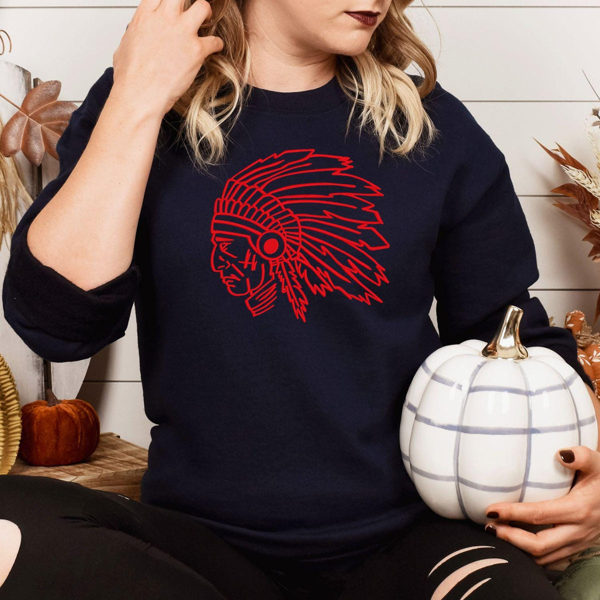 Navy headdress mascot sweatshirt modeled while holding a white pumpkin
