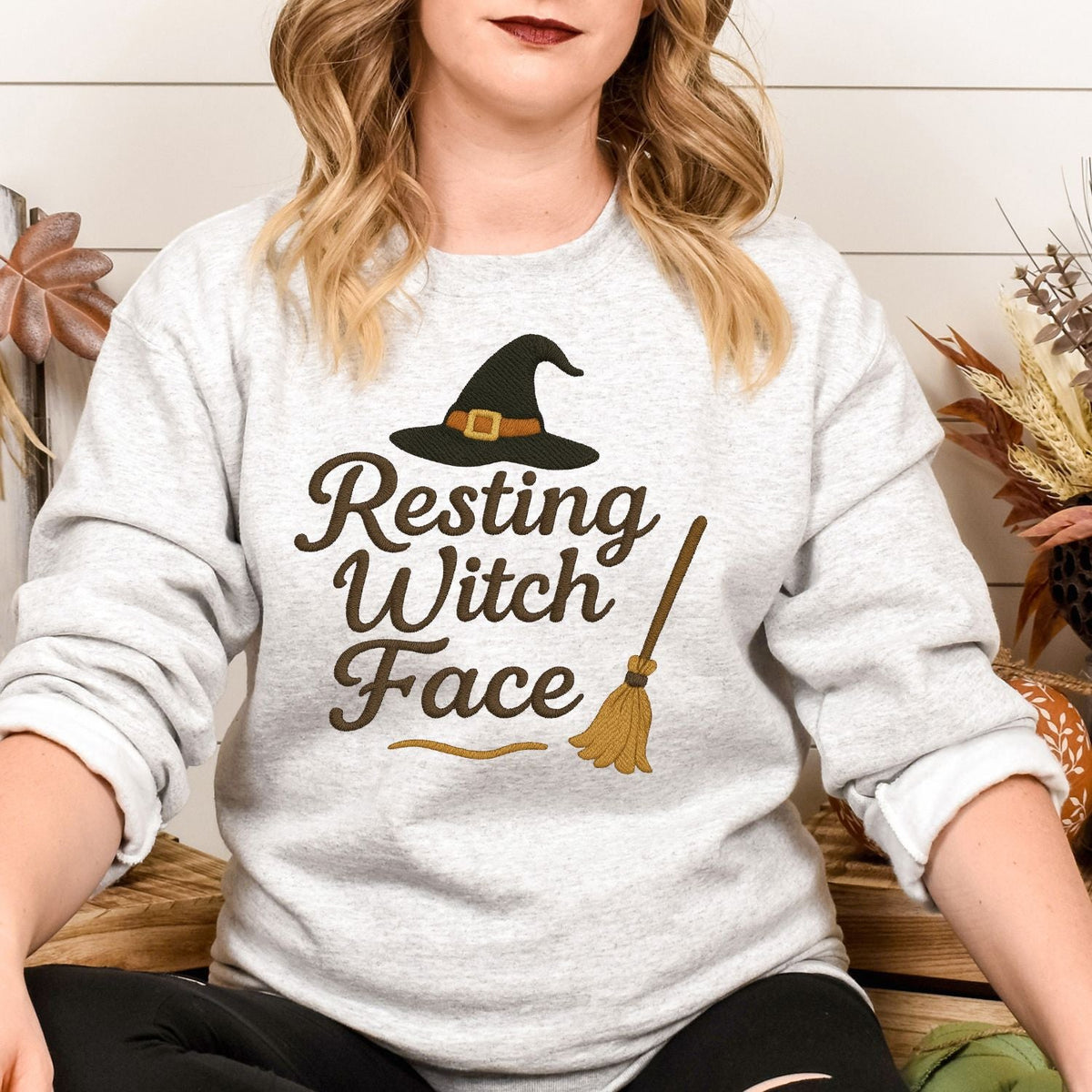 Woman wearing an Ash Resting Witch Face embroidered Gildan sweatshirt