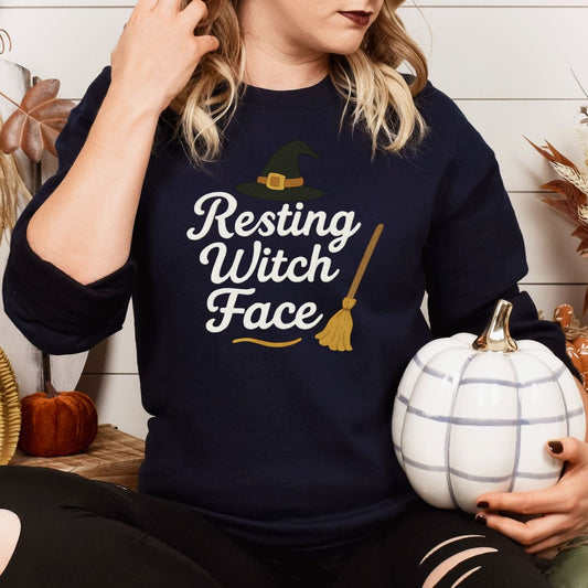 Woman wearing a Navy Gildan Resting Witch Face embroidered sweatshirt with witch hat and broom