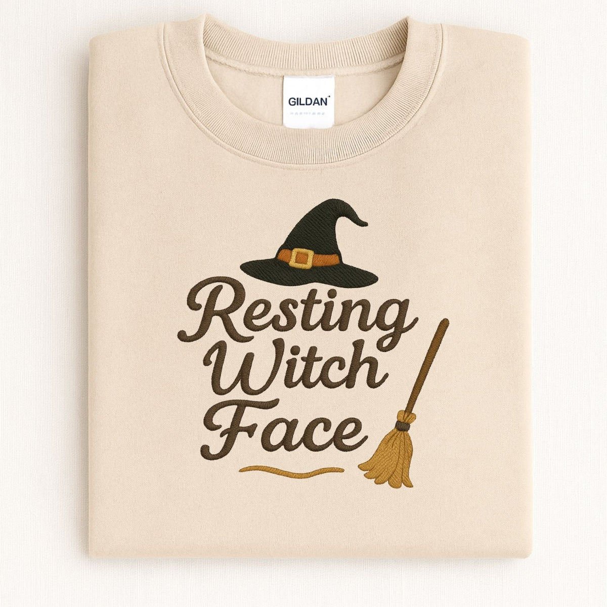 Folded Sand Gildan Resting Witch Face embroidered crewneck