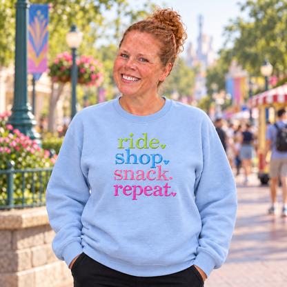 Woman wearing a Carolina Blue Ride Shop Snack Repeat embroidered sweatshirt