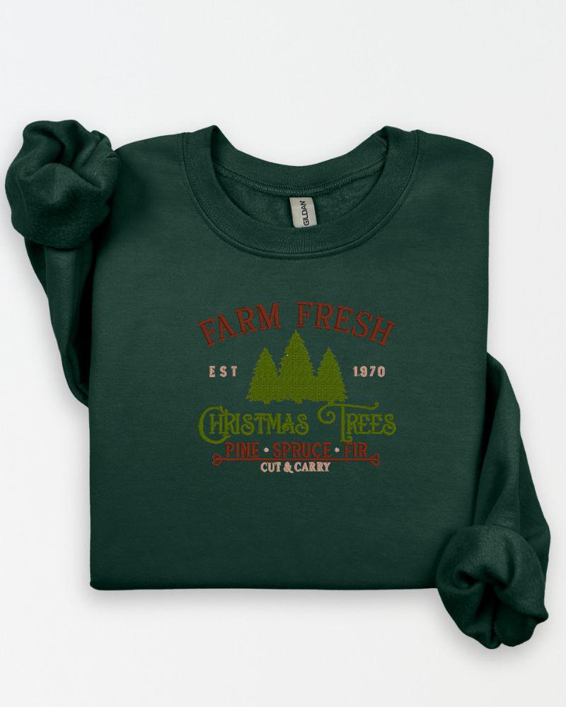 Rustic Farm Fresh Christmas Trees embroidered sweatshirt arranged in a holiday flat lay.