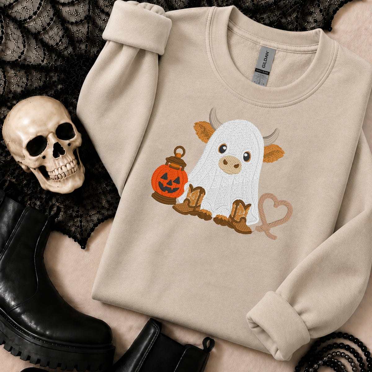 Sand Gildan Softstyle ghost Highland cow embroidered Halloween sweatshirt styled with a skull