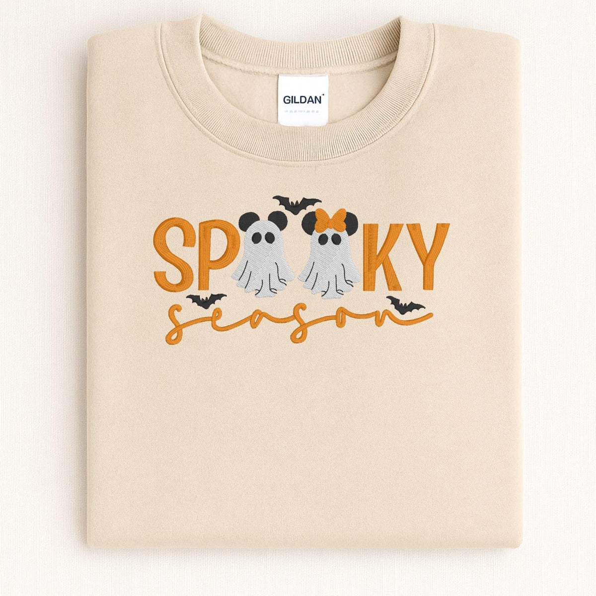 Folded Sand Halloween sweatshirt with two embroidered ghosts and orange lettering