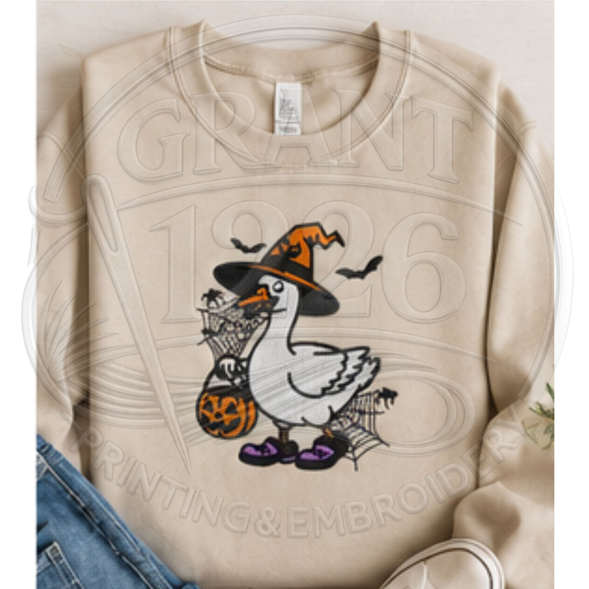 Sand embroidered spooky goose sweatshirt featuring Halloween witch goose and jack-o-lantern treat bucket