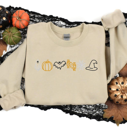 Sand Halloween icons embroidered sweatshirt styled with pumpkins and spiderweb decor