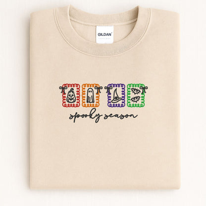 Folded Sand crewneck with colorful Spooky Season Halloween icon embroidery