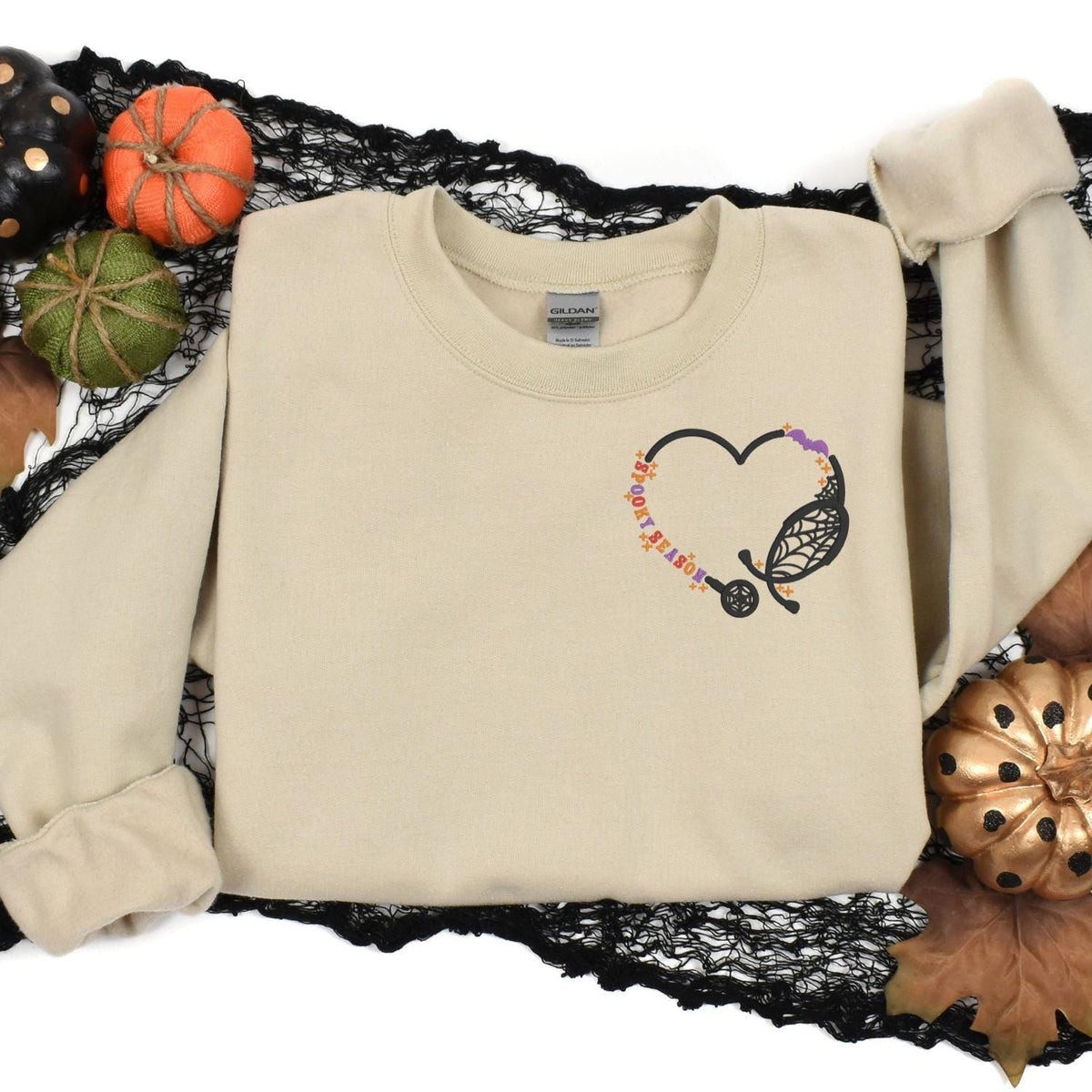 Sand Spooky Season nurse sweatshirt in a Halloween pumpkin flat lay