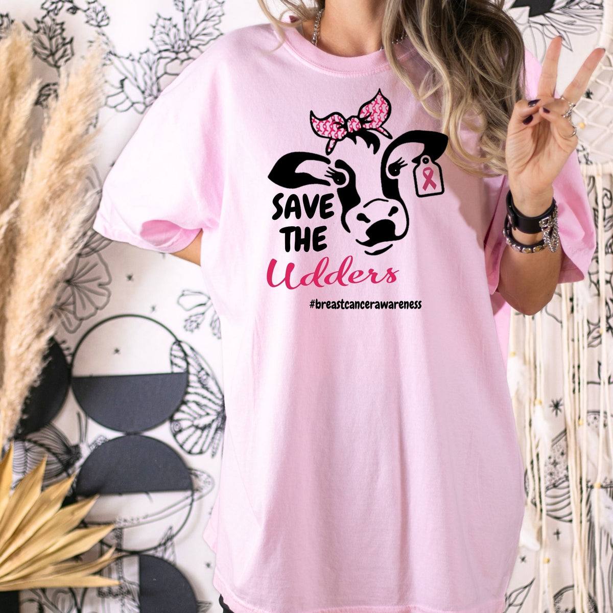 Pink Save the Udders breast cancer awareness tee modeled with a peace sign