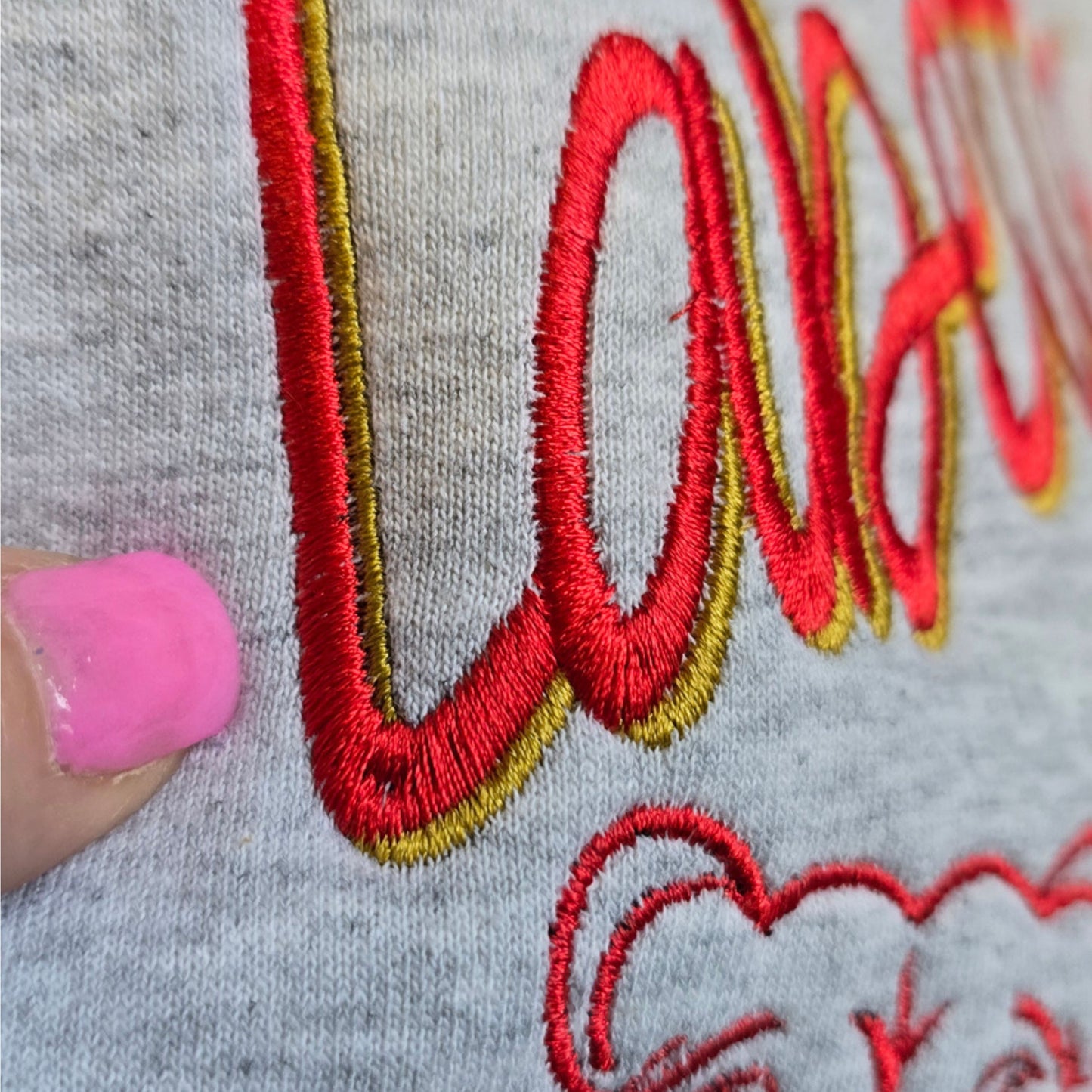 Close-up of premium shadow embroidery showing raised satin stitches, dimensional thread.