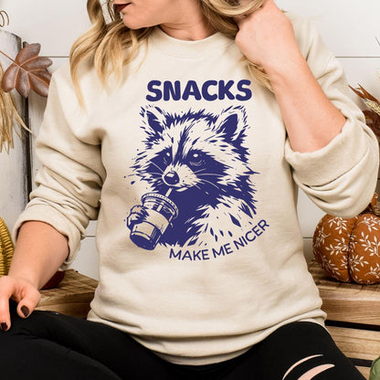 Model wearing sand Snacks Make Me Nicer raccoon graphic sweatshirt