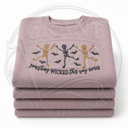 Mauve embroidered Something Wicked Halloween sweatshirt with three dancing skeletons and flying bats