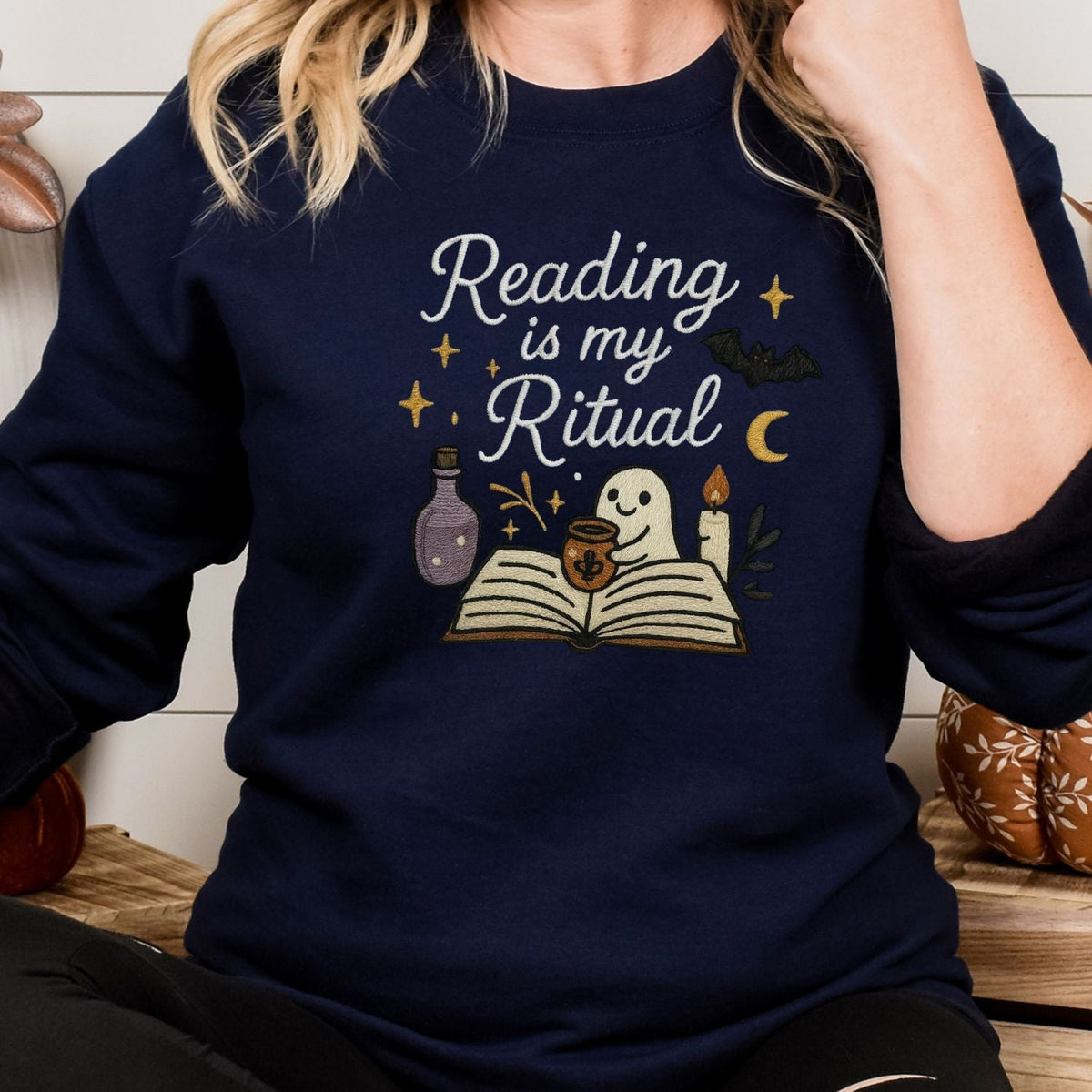 Navy embroidered spooky book lover sweatshirt shown on a model