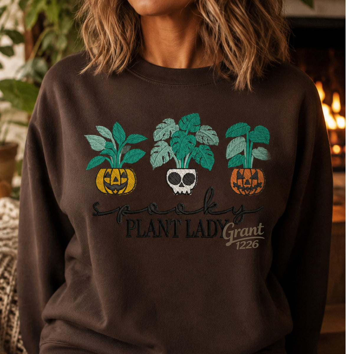 Chocolate Gildan heavyweight Spooky Plant Lady embroidered sweatshirt with pumpkin and skull planter design.