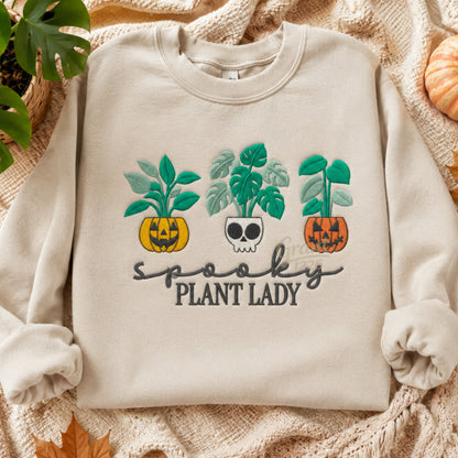 Sand embroidered Spooky Plant Lady Gildan crewneck sweatshirt shown in a fall flat lay.