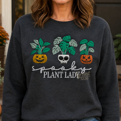 Lifestyle view of Charcoal Heather Gildan embroidered Spooky Plant Lady Halloween sweatshirt.