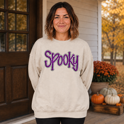 Adult woman wearing a sand Spooky puff embroidered Halloween sweatshirt with purple and gray custom thread