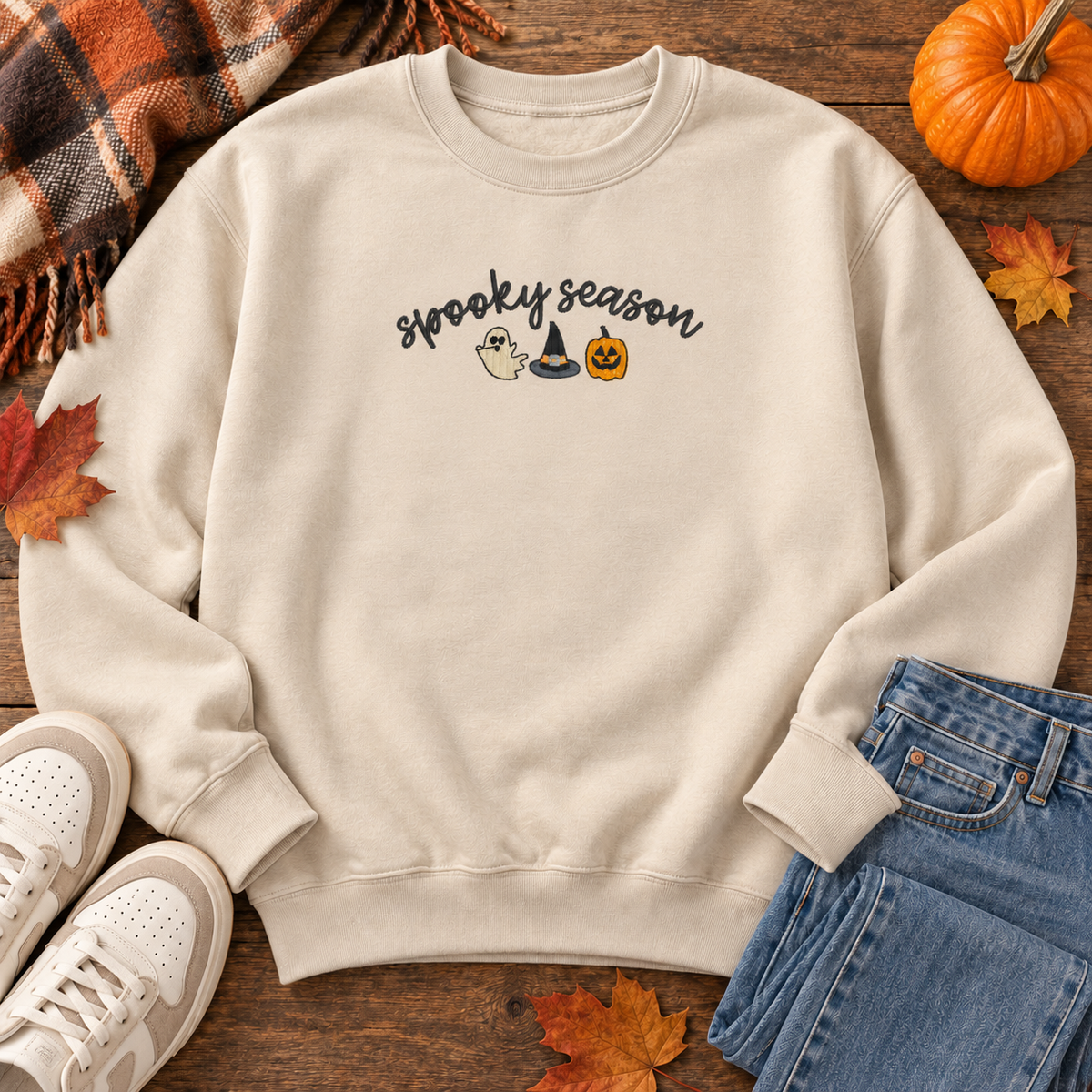 Sand sweatshirt flat lay showing the compact 8 by 3 inch Spooky Season embroidery