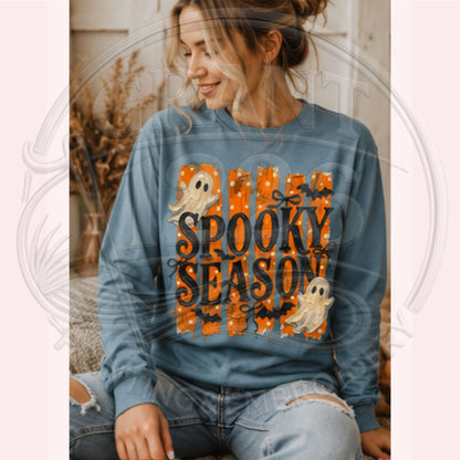 Woman wearing Blue Jean Comfort Colors Spooky Season long sleeve shirt with retro ghosts bats and orange Halloween design