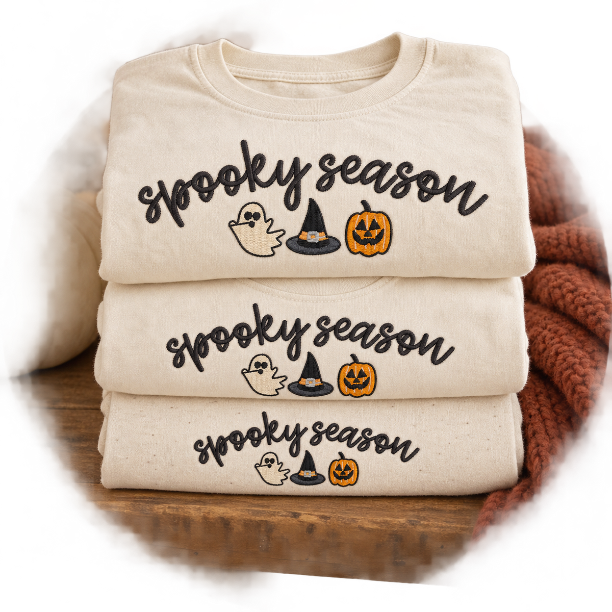 Folded adult youth and toddler ivory shirts with matching Spooky Season embroidery