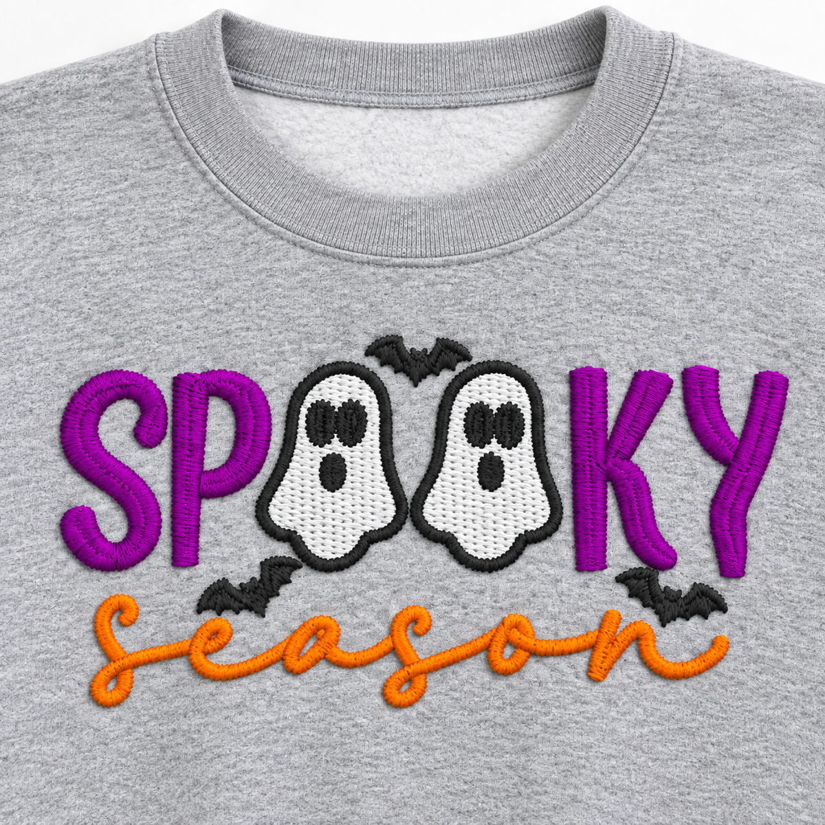 Close-up of purple orange and charcoal Spooky Season ghost embroidery on gray sweatshirt