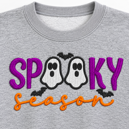 Close-up of purple orange and charcoal Spooky Season ghost embroidery on gray sweatshirt