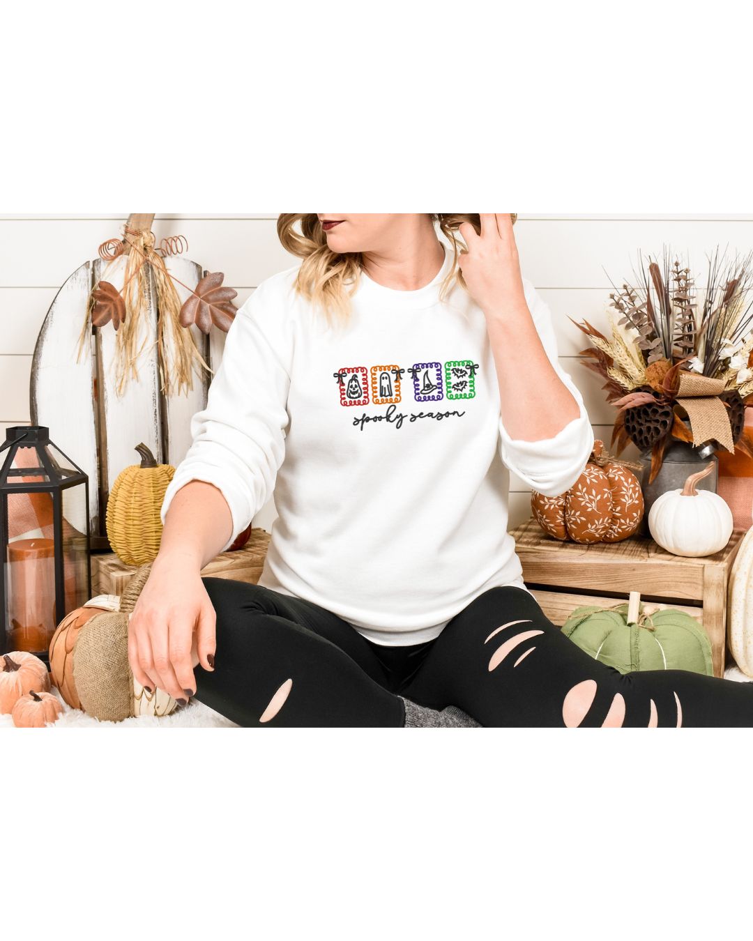 Woman wearing an Ivory long-sleeve Spooky Season Halloween icons embroidered shirt in a fall setting