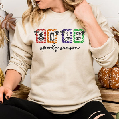 Sand embroidered Spooky Season sweatshirt with pumpkin, ghost, witch hat and bat icons