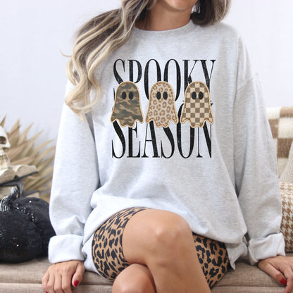 Ash Gildan Softstyle Spooky Season patchwork ghost sweatshirt in a cozy Halloween lifestyle scene