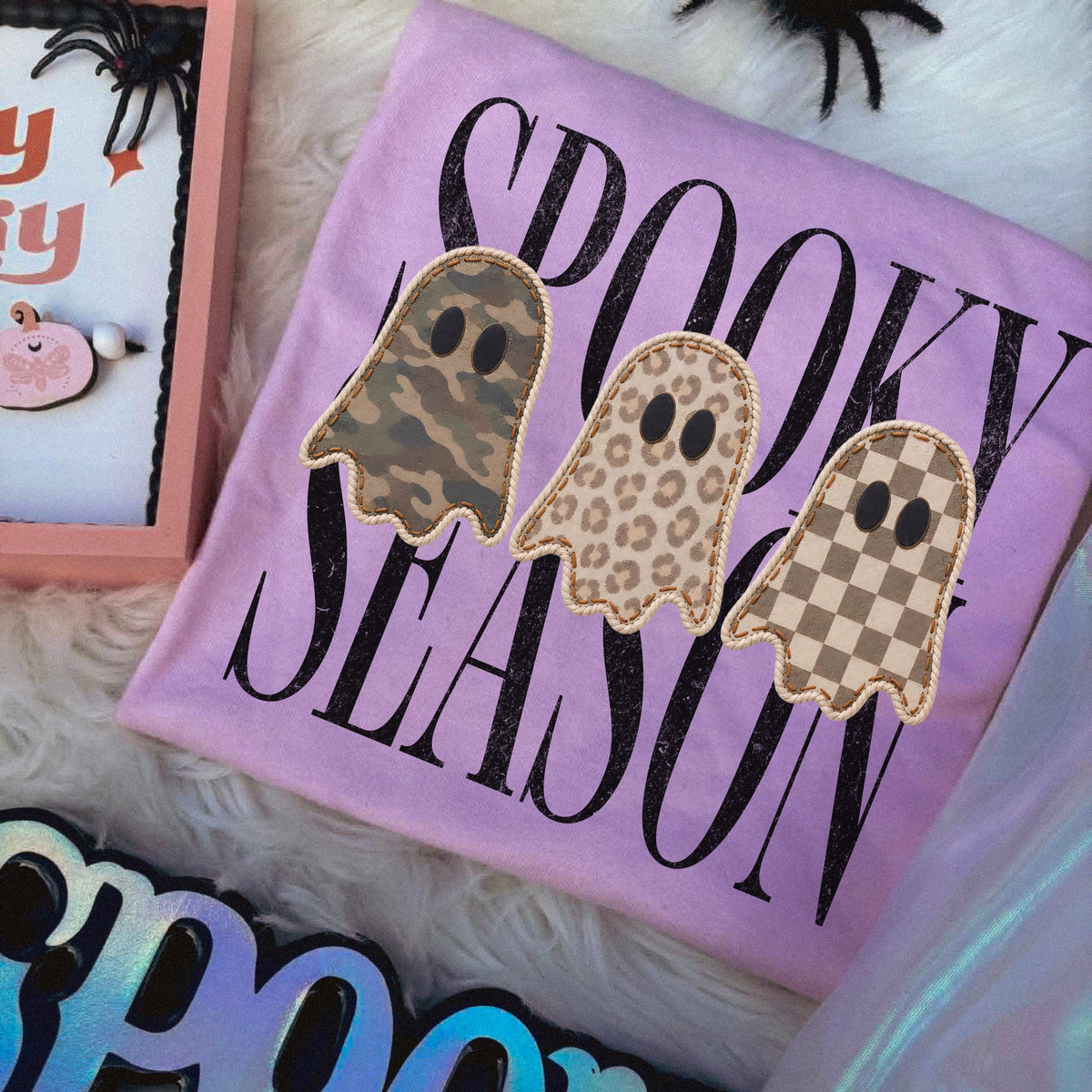Close-up of the camo leopard and checkered Spooky Season ghost design on an Orchid shirt