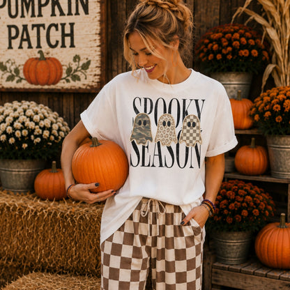 Woman wearing a white Spooky Season patchwork ghost DTG T-shirt at a fall pumpkin patch