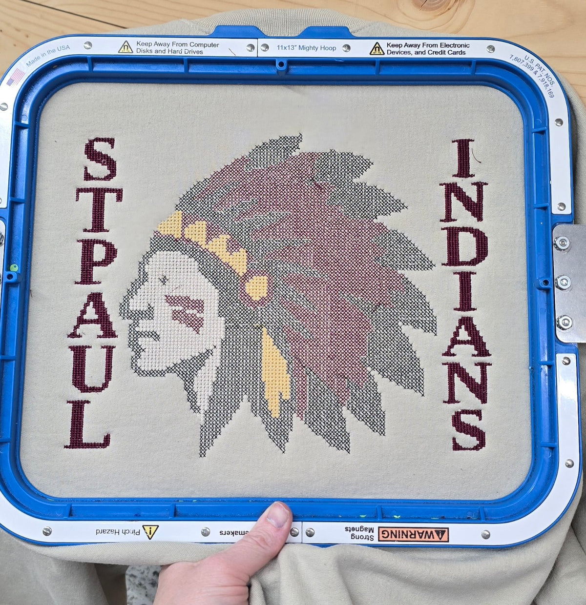 Close-up of St. Paul Indians headdress embroidery on a sand Gildan sweatshirt