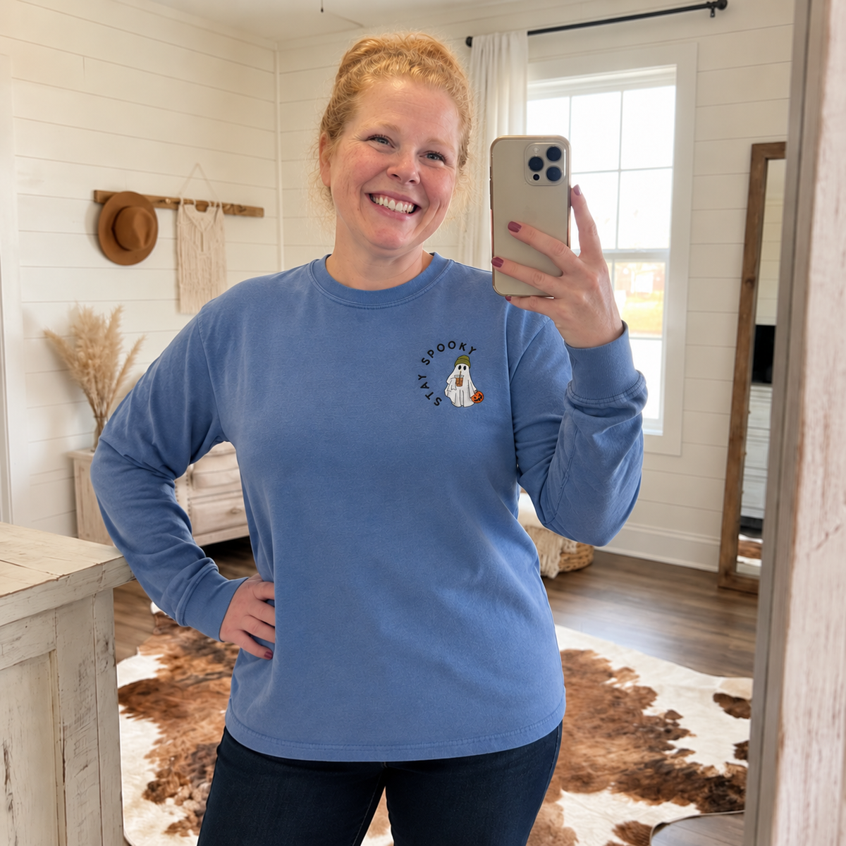 Woman wearing a Blue Jean Comfort Colors long sleeve shirt with left chest Stay Spooky ghost embroidery