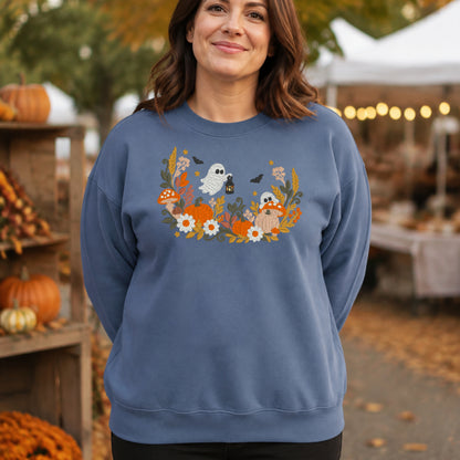 Woman wearing a Stone Blue floral ghost and pumpkin embroidered Halloween sweatshirt